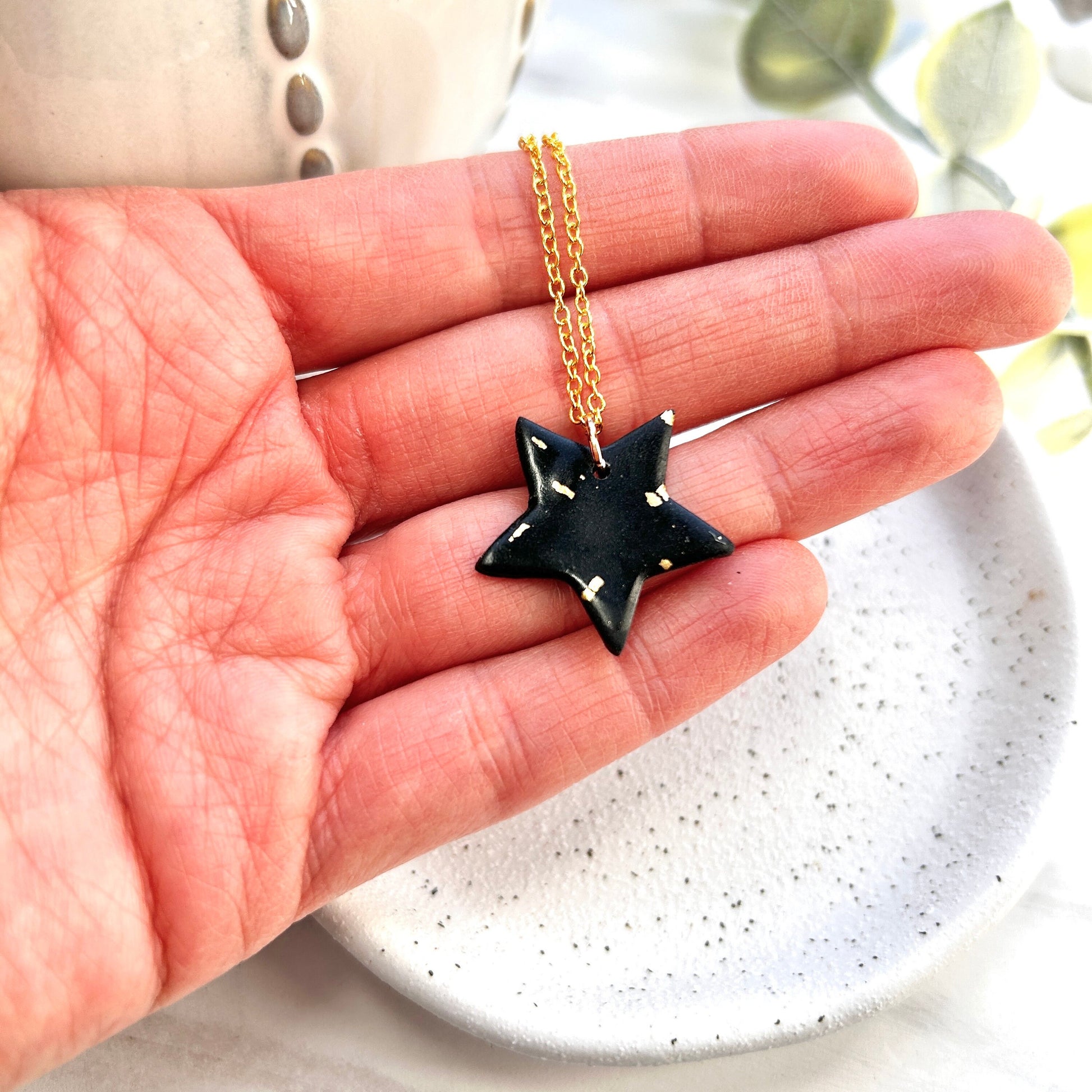 Stunning black and gold polymer clay star necklace on an 18 inch gold plated chain