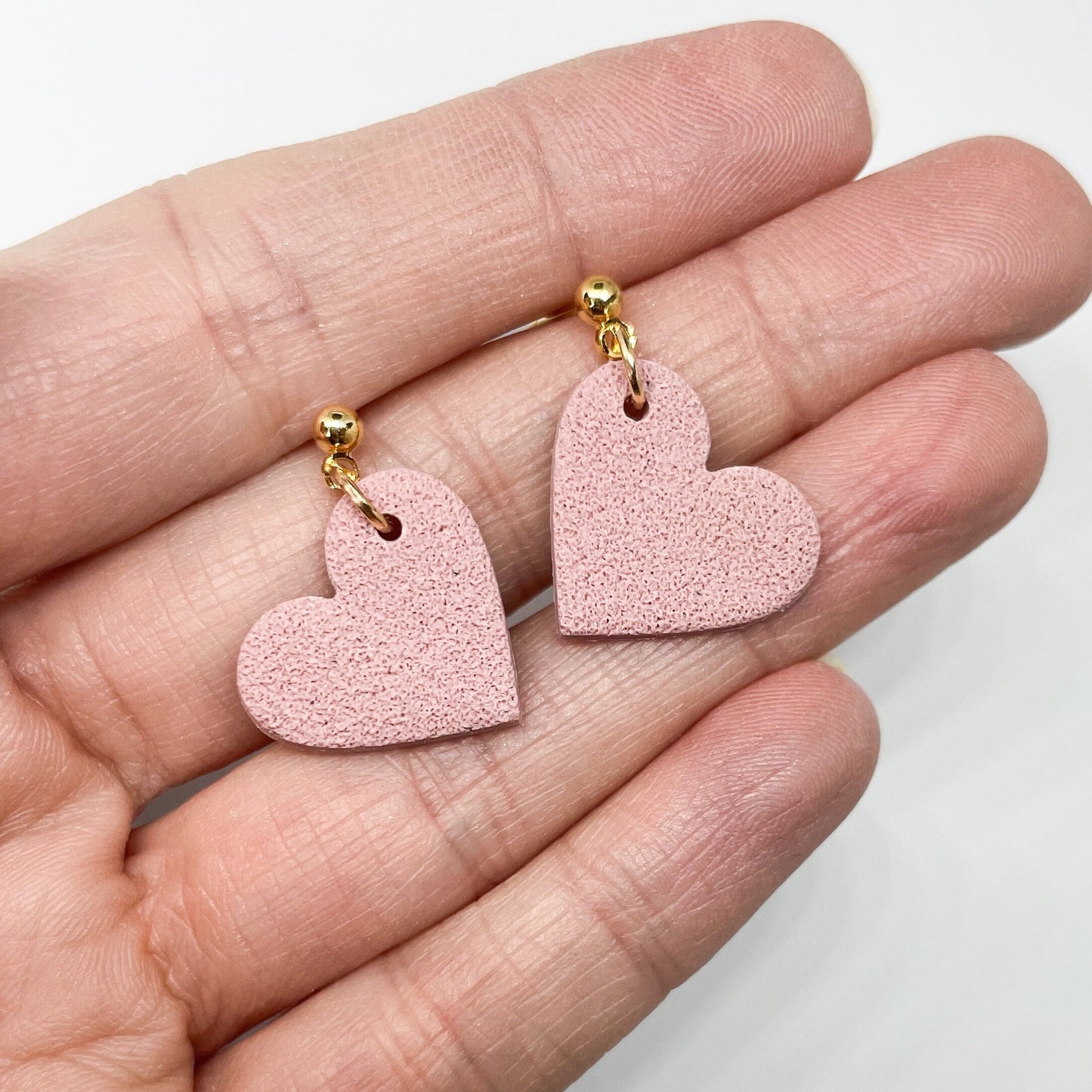 Mended heart, pink and black polymer clay stud earrings.